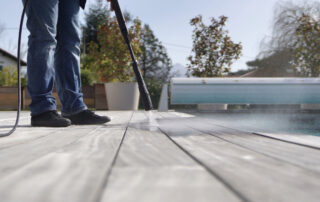 Man using high pressure washer cleaning deck