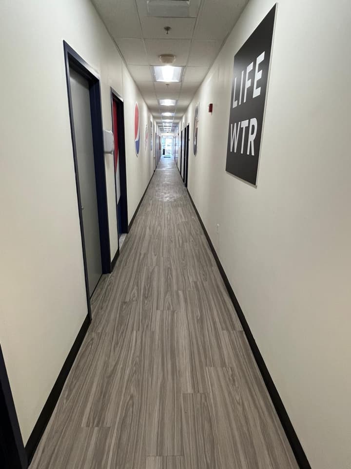 White walls and wooden floors in a long hallway