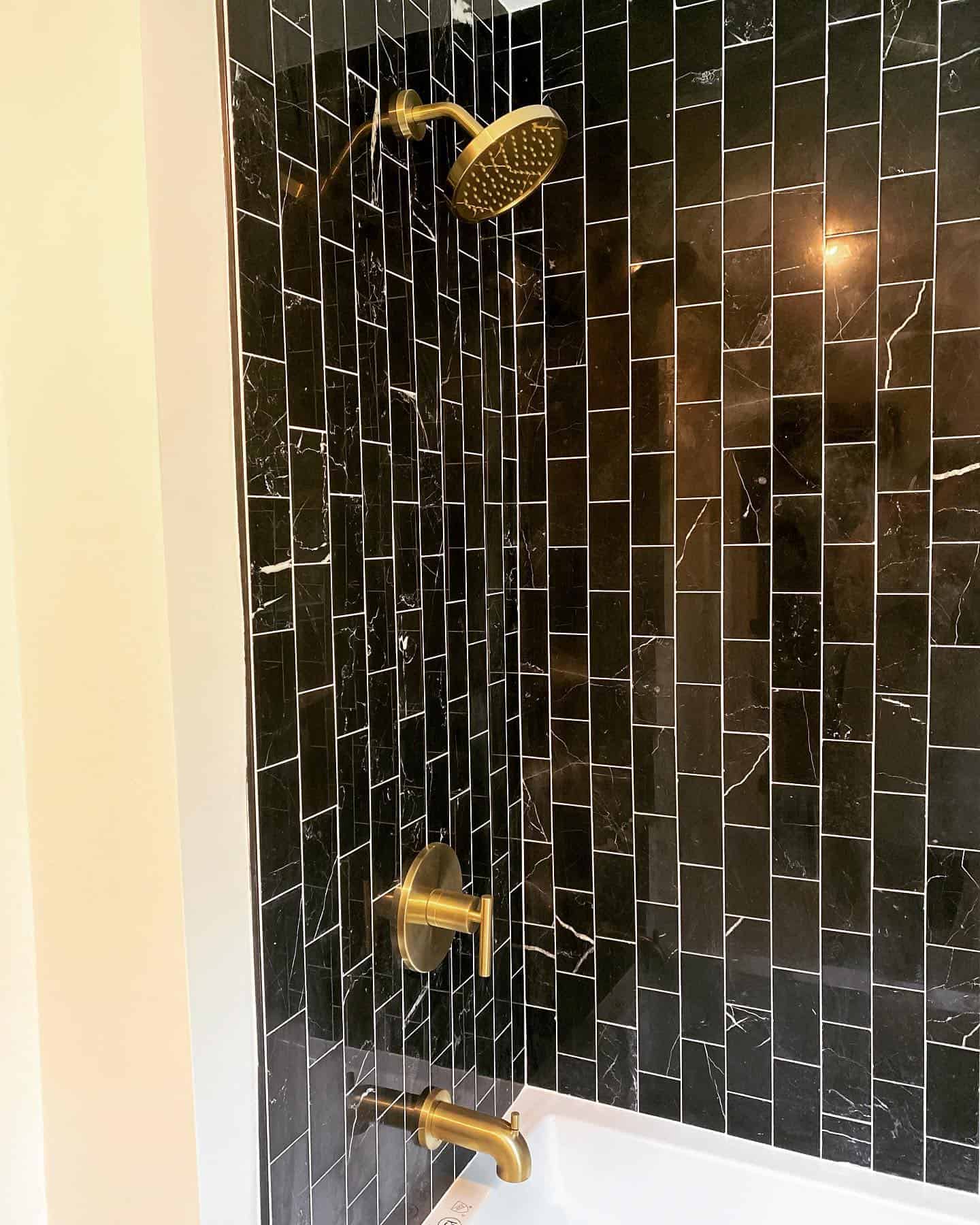 Gold shower and faucet with black ceramic tiles